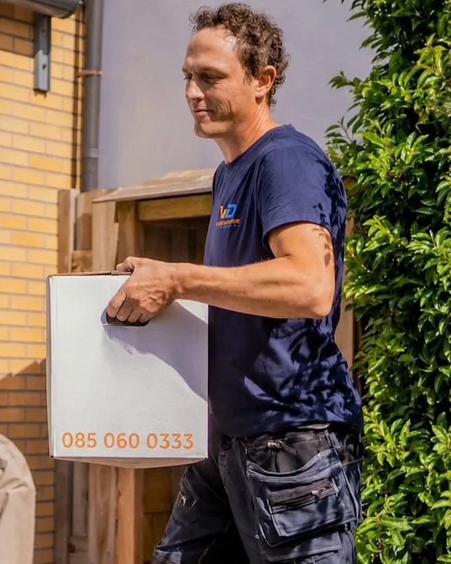 Verhuizer van Verhuisbedrijf Draagkracht draagt een ingepakt stuk zorgvuldig naar buiten