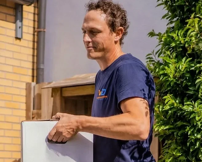 Verhuizer van Verhuisbedrijf Draagkracht draagt voorzichtig een doos